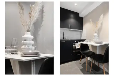 a kitchen with a table with chairs and a white vase at Renovated jan 24 - Queen beds - Behind Bryggen in Bergen