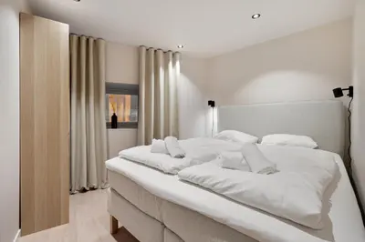a large white bed with white sheets and pillows at Renovated jan 24 - Queen beds - Behind Bryggen in Bergen