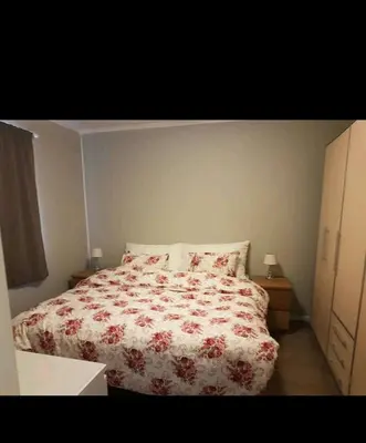 a bedroom with a bed with a red and white comforter at Hus ved sjøen in Bakken