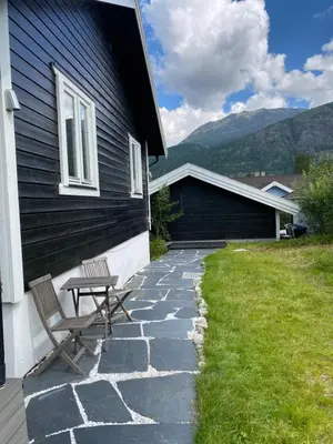 a patio with two chairs and a table next to a house at 2 mannsbolig i Hemsedal sentrum, nær skianlegget - 3 sov og 7 sengeplasser in Hemsedal