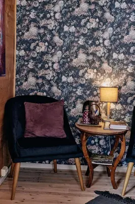 a living room with a chair and a table with a lamp at Flatheim in Viksdalen
