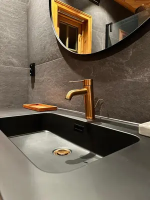 a bathroom sink with a faucet and a mirror at Trysil Moderna Lodge in Trysil