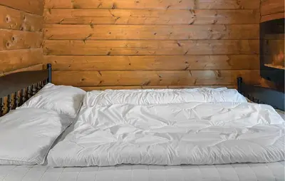 an unmade bed in a room with a wooden wall at Lovely Home In Stranda With Wifi in Stranda