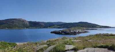 a large body of water with mountains in the background at Apartment Solbakken Feriehus in Fevåg