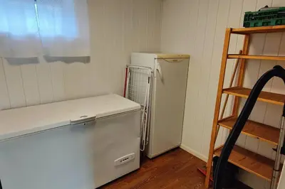 a kitchen with a white refrigerator and a shelf at Apartment Solbakken Feriehus in Fevåg
