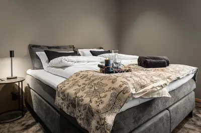 a large bed with a blanket on top of it at Toppleilighet på bryggen i Sogndal med fantastisk utsikt in Sogndal