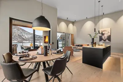 a dining room and living room with a table and chairs at Toppleilighet på bryggen i Sogndal med fantastisk utsikt in Sogndal