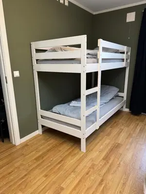 two white bunk beds in a room with wood floors at Stue, soverom og bad in Åmot