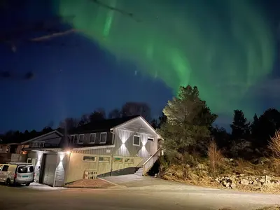 a house with the aurora in the sky at Ekskluzywny hybel w zaciszu in Kristiansund