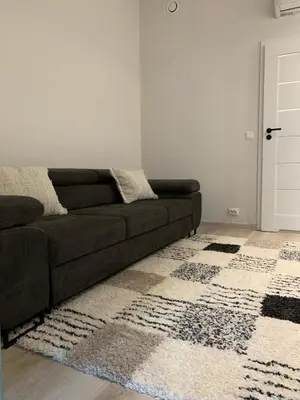 a living room with a brown couch and a rug at Ekskluzywny hybel w zaciszu in Kristiansund