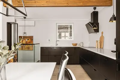 a kitchen with black cabinets and a white counter top at Bryggen Hideaway I Lux Feeling & Private Patio in Bergen