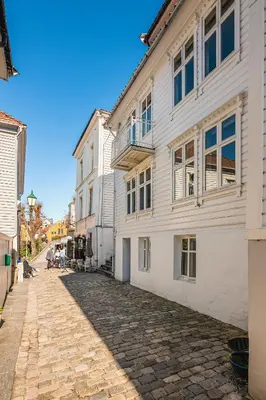 a cobblestone street in front of a white building at Bryggen Hideaway I Lux Feeling & Private Patio in Bergen