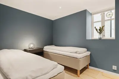 a bedroom with two beds and a window at Bryggen Hideaway I Lux Feeling & Private Patio in Bergen