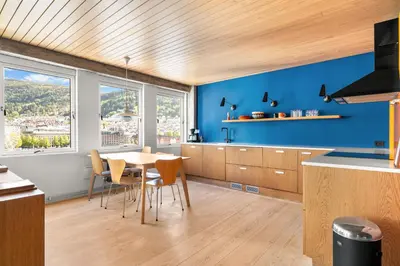 a kitchen with blue walls and a table and chairs at Unique gem overlooking the world famous Bryggen in Bergen