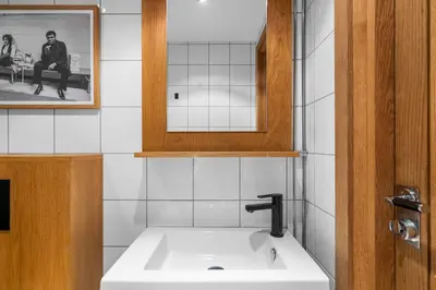 a bathroom with a white sink and a mirror at Unique gem overlooking the world famous Bryggen in Bergen