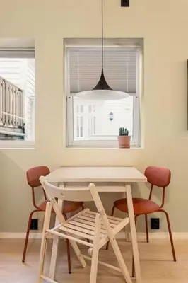 a table and chairs in a room with a window at Fresh studio apartment, a short walk from Bryggen in Bergen