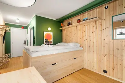a bedroom with a bed in a wooden wall at Unique Studio I Custom Built I 500 Meters From Bryggen in Bergen