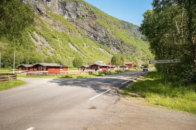 an empty road with houses and a mountain at Utladalen Camping in Årdal