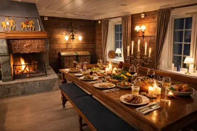 a dining room with a table with food and a fireplace at Eventyrlig Tømmerhytte på Gårdstun in Vinstra