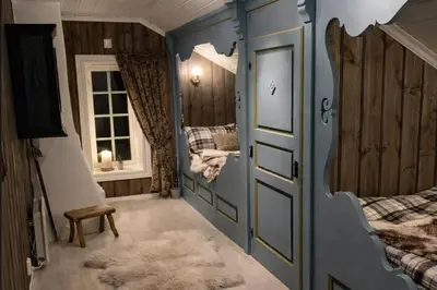 a bedroom with two beds and a window and a door at Eventyrlig Tømmerhytte på Gårdstun in Vinstra