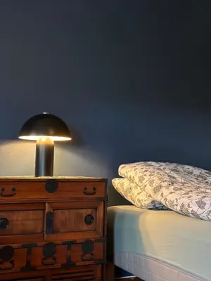 a lamp on top of a dresser next to a bed at Lovely fully furnished apartment in Ottestad