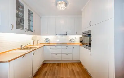 a white kitchen with white cabinets and wooden floors at Awesome Home In Ånneland With Wifi in Ånneland
