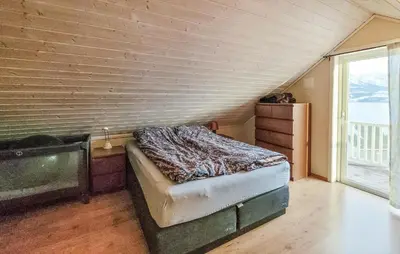 a bedroom with a bed in a room with a window at 4 Bedroom Awesome Home In Tørvikbygd in Tyrvikbygd