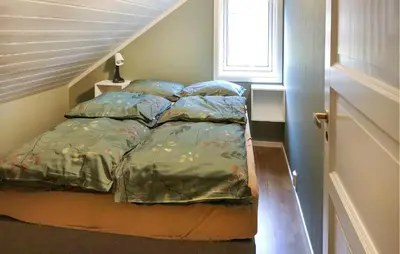 a bed in a small room with a window at 4 Bedroom Awesome Home In Tørvikbygd in Tyrvikbygd