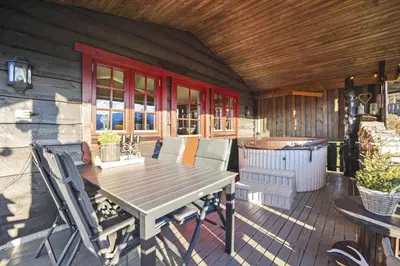 a wooden deck with a table and chairs on a house at Hytte Stryn skisenter in Stryn