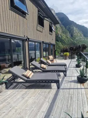 three benches sitting on a deck next to a building at Flo Bellevue in Stryn