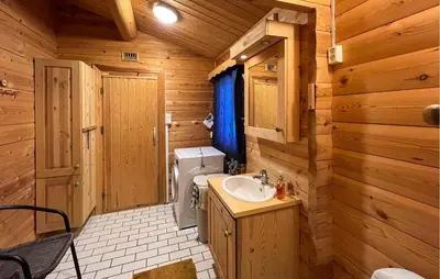 a bathroom with a sink and a toilet in a log cabin at Awesome Home In Venabygd With Sauna in Venabygd