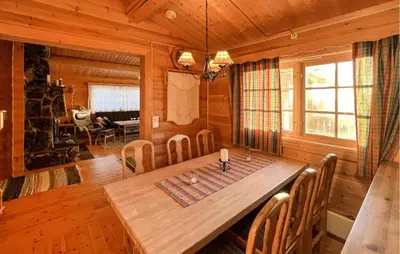 a dining room with a wooden table and chairs at Awesome Home In Venabygd With Sauna in Venabygd