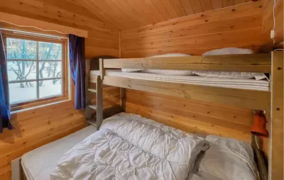 two bunk beds in a log cabin with a window at Awesome Home In Venabygd With Sauna in Venabygd