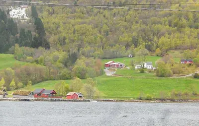 a group of houses on a hill next to a body of water at Lovely Home In Bjordal With Kitchen in Bjordal
