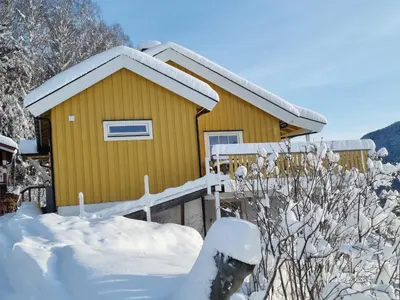 a small yellow house with snow on it at Solhaug in Torpo