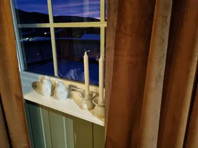 a bathroom sink with a window with a candle at Solhaug in Torpo