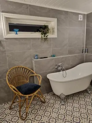 a bathroom with a tub and a chair in it at Solhaug in Torpo