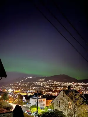 a view of a city at night with a green sky at Spacious and Beautiful Apartment in Bergen with free parking in Bergen