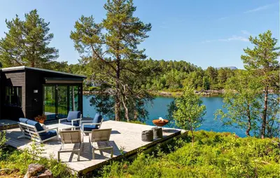 a house with chairs and a dock on a lake at 4 Bedroom Lovely Home In Skodje in Skodje