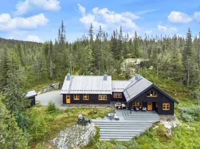 an aerial view of a large wooden house in the woods at Your Ideal Getaway Awaits in This Charming Cabin Retreat in Nord Torpa