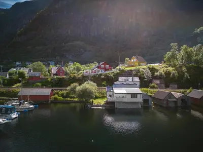 an aerial view of a village on a body of water at Sjötun Fjord Cabin, with boat in Stanghelle