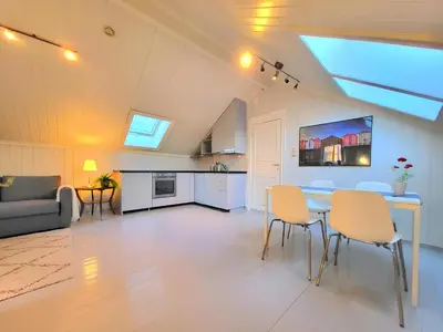 a kitchen and living room with a table and chairs at Mercury House, Cathedral View ! Free Parking ! in Trondheim