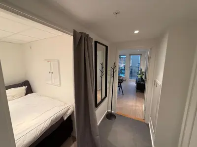 a small bedroom with a bed and a hallway at New penthouse apartment with sea view in Bergen centrum in Bergen