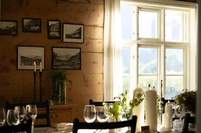 a dining room with a table with wine glasses at Hotel Aak in Åndalsnes