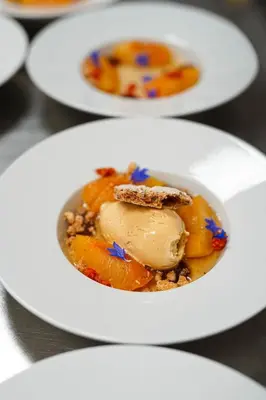 a white plate with a bowl of food on a table at Hotel Aak in Åndalsnes