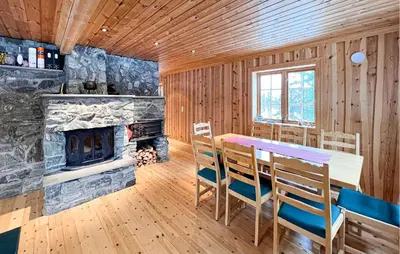 a dining room with a table and a fireplace at 2 Bedroom Nice Home In Aust- Torpa in Aust-Torpa