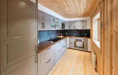 a kitchen with white cabinets and a wooden ceiling at 2 Bedroom Nice Home In Aust- Torpa in Aust-Torpa