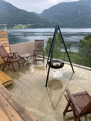 a porch with chairs and a swing and a lake at Turer, avslapping, jakt, fiske, utsikt in Etnesjøen