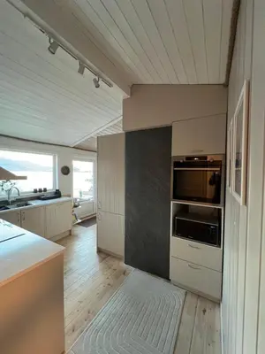 a kitchen with white cabinets and a stove top oven at Turer, avslapping, jakt, fiske, utsikt in Etnesjøen