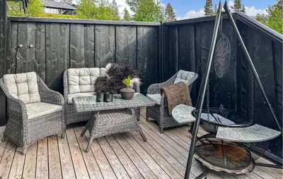 a patio with chairs and a table on a wooden deck at 3 Bedroom Gorgeous Home In Bjorli in Bjorli